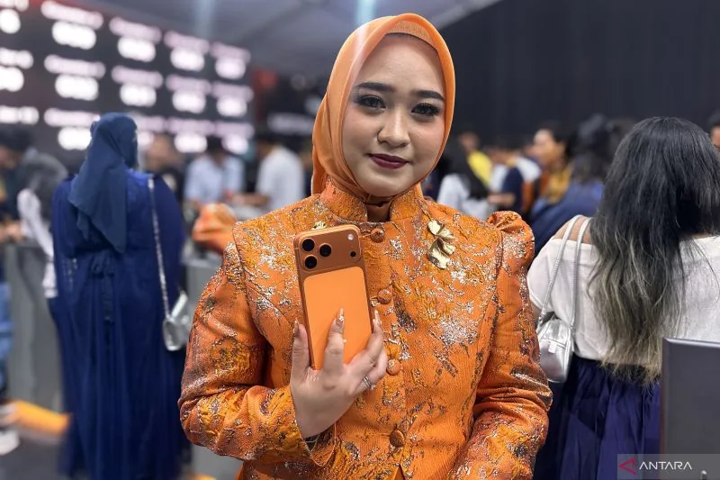 Dina berpose bersama iPhone 17 miliknya berpose di iBox Senayan City, Jumat (17/10/2025). Foto: ANTARA/Pamela Sakina