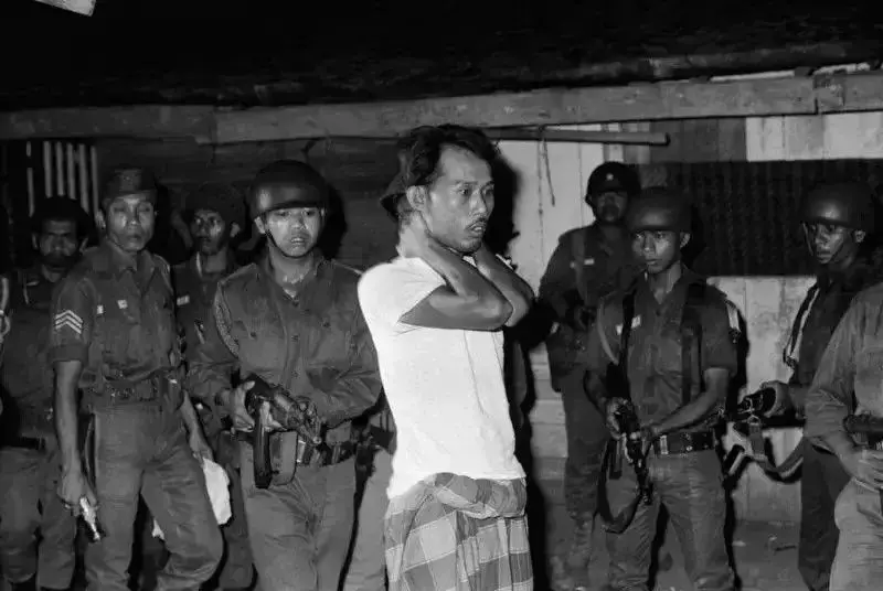 Seorang warga yang dituduh simpatisan PKI di Pulau Jawa digelandang TNI.